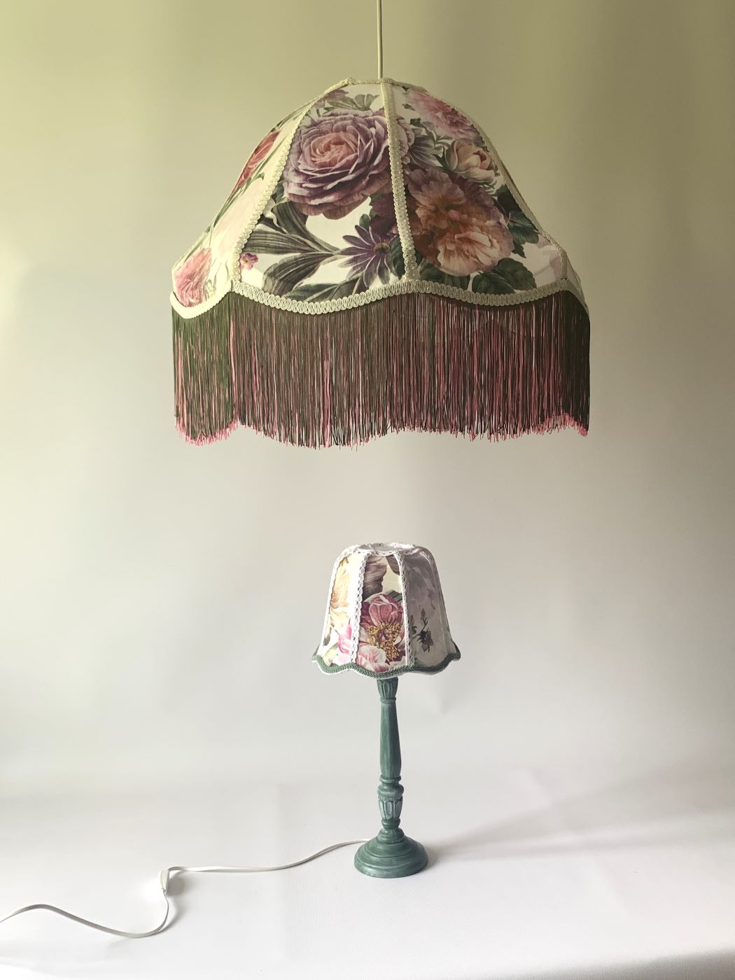 Zestaw oświetleniowy w stylu vintage: wisząca lampa sufitowa oraz pasująca lampka stołowa z kwiatowymi abażurami i frędzlami